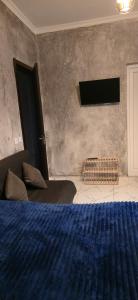 a bedroom with a bed and a tv on a wall at Vato tkhilaishvili in Kobuleti