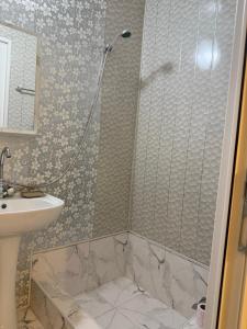 a bathroom with a shower and a sink at Nanini Apartment in Tbilisi City +3 photos