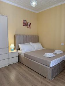 a bedroom with a large bed with a large headboard at Nanini Apartment in Tbilisi City