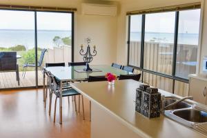 a kitchen and dining room with a view of the ocean at Edgewater Escape Kangaroo Island in Kingscote