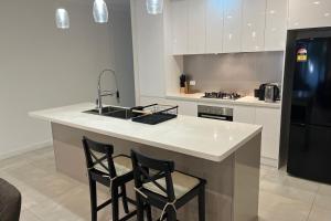 a kitchen with two chairs at a kitchen island with a sink at Timeless Tranmere Escape By Host Solutions in Norwood