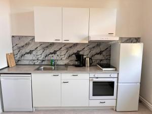 Una cocina blanca con gabinetes blancos y un fregadero. en Arbeiter - Lounge 1, en Salzgitter