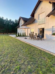 a patio with chairs and a table in front of a house at Lasy Jeziora, Cisza i Spokój, Grzybki i Rybki, Dom 180m2 w Swornegacie nad jeziorem Karsińskim in Swornegacie  +39 photos