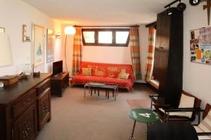 a living room with a red couch and a table at Résidence La Mazeliere - Appartement pour 6 personnes MAE-6243 in Le Mélézet