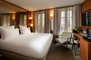 a hotel room with a large white bed and a desk at Hôtel Villa Madame - Saint-Germain-des-Prés in Paris
