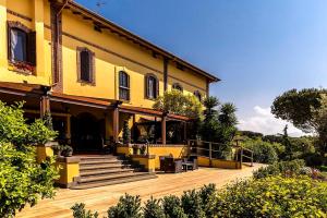 a large yellow house with a deck and stairs at Boma Countryhouse in Casale Bufalotta