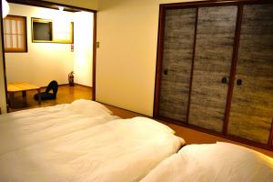 a bedroom with a large white bed and a sliding glass door at 飛騨棲家 八幡宿 - Hida Sumika Hachimanyado in Takayama +32 photos