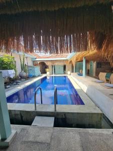 a large swimming pool with a straw roof at Lavender Villa 7 Moon House in Kuta