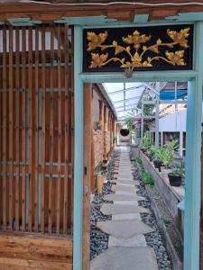 una entrada a un jardín con una puerta de madera en Lavender Moon House ex Lavender villa 7, en Kuta
