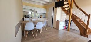 una cocina con mesa y sillas blancas y una escalera en KAPI ośrodek wczasowy w Mielnie, en Mielno