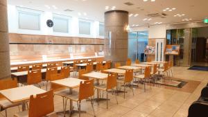 Toyoko Inn Niigata Ekimae في نيغاتا: صف من الطاولات والكراسي في الكافتريا