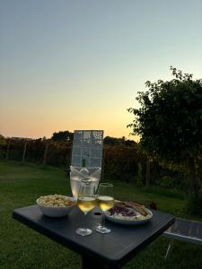 a table with two glasses of wine and food on it at Dammuso Ingarao in Marsala