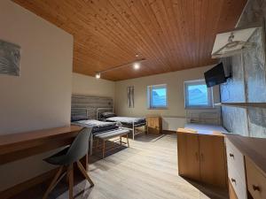 a room with two beds and a desk in it at Gästehaus Back - Reisfelder Hof in Reinsfeld