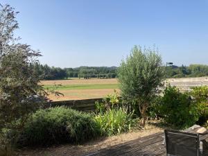 a view of a field with a fence and trees at accommodation for 4 people maximum in Guignen