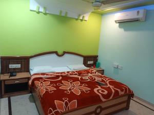 a bedroom with a bed with a red and white bedspread at Hotel Sabar inn in Ahmedabad +14 photos