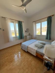 Un dormitorio con una cama y un ventilador de techo. en Summer family house 300m from the beach, en Kastraki Naxou 45 fotos más