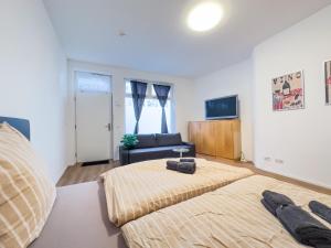 a bedroom with a bed and a couch and a television at Moderne Wohnung im Zentrum der Altstadt - Altbau Flair, WLAN in Ingolstadt