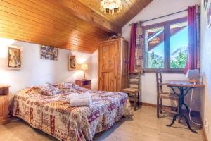 莱德萨阿尔卑斯Spacious cottage with view on the Muzelle的一间卧室，里面有一张床、一张桌子和一扇窗户