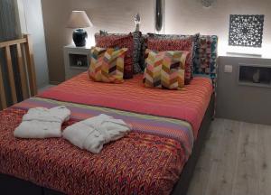 a large bed with two towels on top of it at Gite Spa les Estinnes in Estinnes-au-Mont