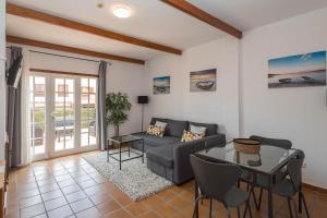 a living room with a couch and a table at Lightbooking Las Breñas Garden con piscina in Breña Baja