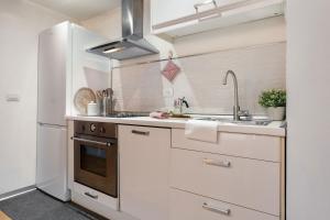 una cucina bianca con lavello e frigorifero di Keys of Italy - Rustici 3 - Charming 1BR Loft a Firenze