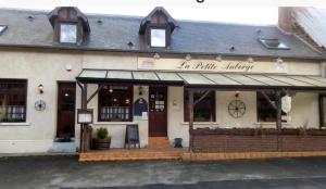 a building with a sign that reads a little library at La petite auberge 