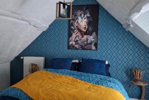 a bedroom with a bed and a painting on the wall at La petite auberge 