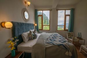 1 dormitorio con 1 cama con cabecero azul y ventanas en kampreyan heights, en Manali