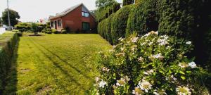 a garden with flowers in front of a house at Holiday Home Villa Zonnebeke in Zonnebeke +1 photo
