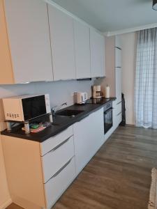 a kitchen with white cabinets and a sink at Traumoase in Timmendorfer Strand in Timmendorfer Strand +23 photos