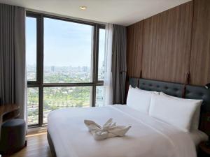 a hotel room with a bed with a bow on it at Oakwood Suites Tiwanon Bangkok in Nonthaburi