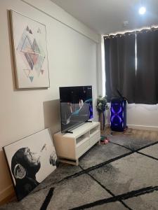 a living room with a tv and a table at Central southsea Apartment in Portsmouth