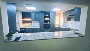 cocina con armarios azules y encimera de mármol en Luxury Villa, en Ras al Khaimah