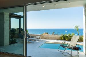 ein Haus mit einer Terrasse mit Blick auf das Meer in der Unterkunft My Cave Blue Iconic Designer Villa by the Sea in Rethymno