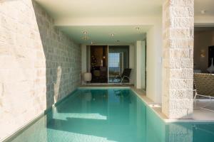 ein Pool mit blauem Wasser in einem Haus in der Unterkunft My Cave Blue Iconic Designer Villa by the Sea in Rethymno