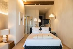 ein Schlafzimmer mit einem großen Bett mit weißen Laken und Kissen in der Unterkunft My Cave Blue Iconic Designer Villa by the Sea in Rethymno