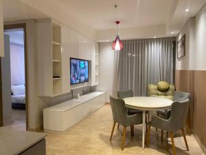 a room with a table and chairs and a bedroom at Comfort and Luxury Private Room at Goldcoast PIK in Jakarta