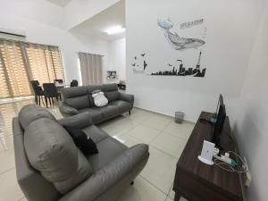 a living room with a couch and a television at Padang Serai Taman Ria 61 in Padang Serai