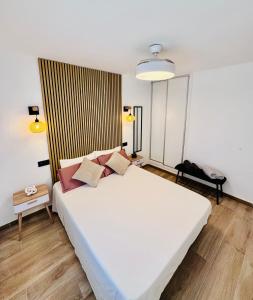 a bedroom with a large white bed with pink pillows at Leo Apartamentos La Cova in Peniscola +16 photos