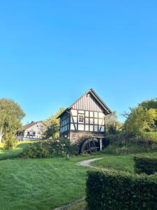 ein Haus auf einem Hügel mit einem grünen Hof in der Unterkunft Ferienwohnung Wanderglück Latrop in Schmallenberg