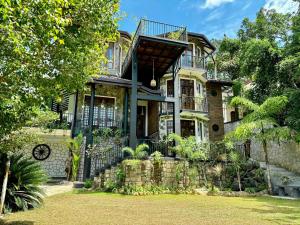 a house with a balcony on top of it at Winterfell Bandarawela in Bandarawela