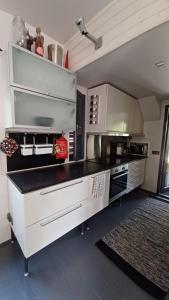 une grande cuisine avec des appareils blancs et un tapis dans l'établissement Arctic Villa Iisakki, à Rovaniemi