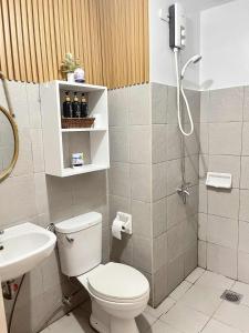 a bathroom with a toilet and a shower and a sink at Cozy Mesatierra Garden by Adi Staycation Dvo in Davao City