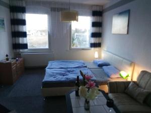 ein Hotelzimmer mit einem Bett und einer Couch in der Unterkunft Ferienwohnung am Yachthafen in Ueckermünde