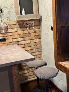 una cocina con dos taburetes junto a una pared de ladrillo en Highlife Apartment Luxury Two Wiesbaden, en Wiesbaden