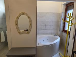 a bathroom with a tub and a mirror on the wall at Alloggio turistico di Stefano in Lido di Ostia