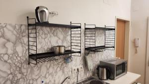 eine Küche mit schwarzen Regalen an der Wand in der Unterkunft The Smart Flat in Wien