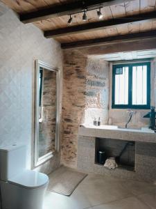 a bathroom with a toilet and a sink and a window at Dona Remedios in Xermade