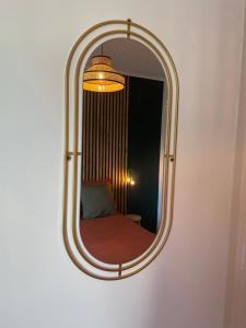 a mirror on a wall with a bed in it at Chez Elo in Tours