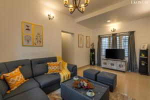 a living room with a couch and a tv at EKOSTAY - Villa Eve in Ooty